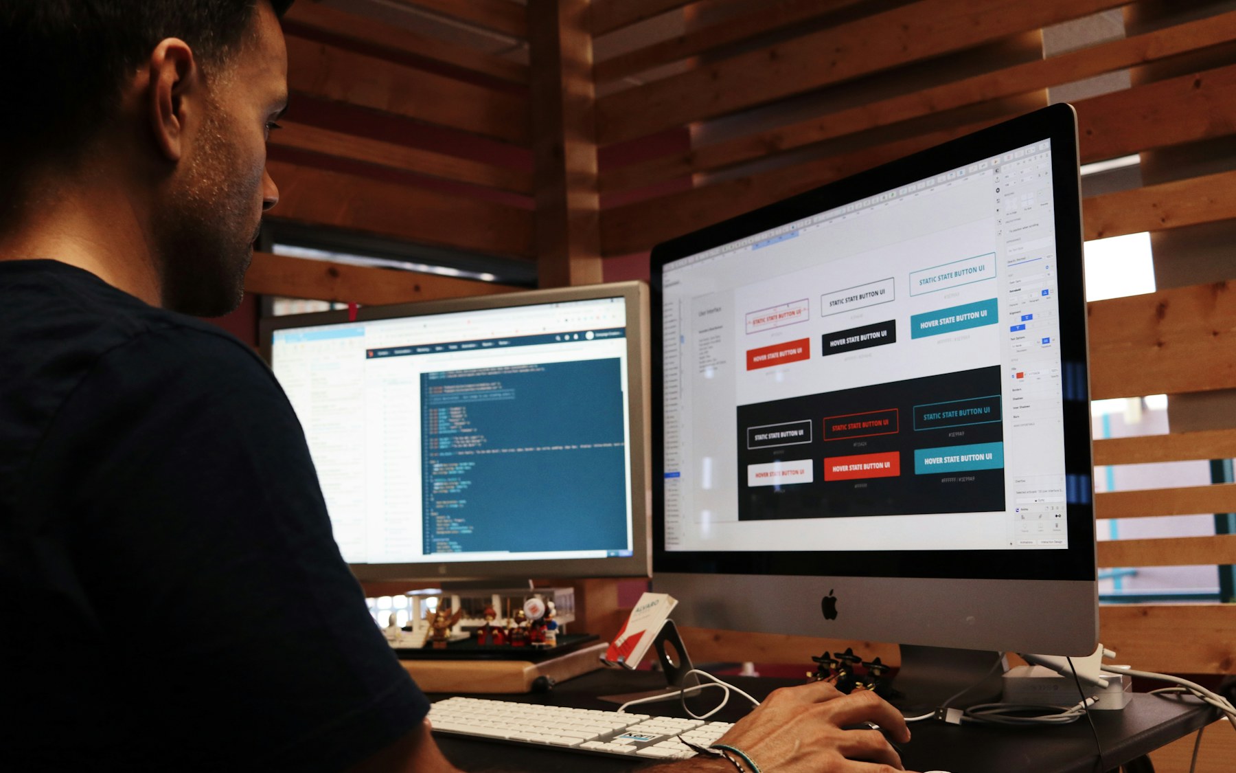 Professional working at a desk with dashboards on two monitors