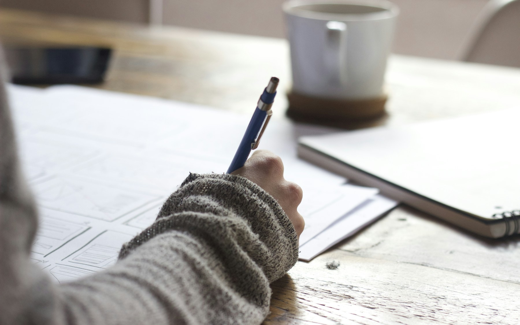 Person reviewing documents and taking notes with a pen