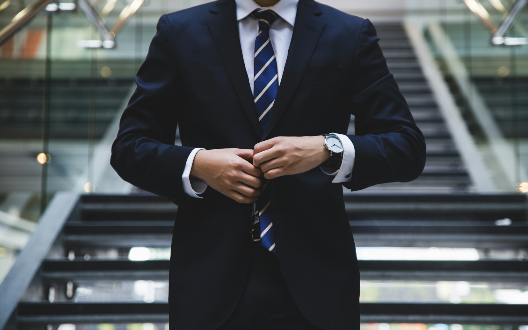 Executive in a suit standing on an office staircase