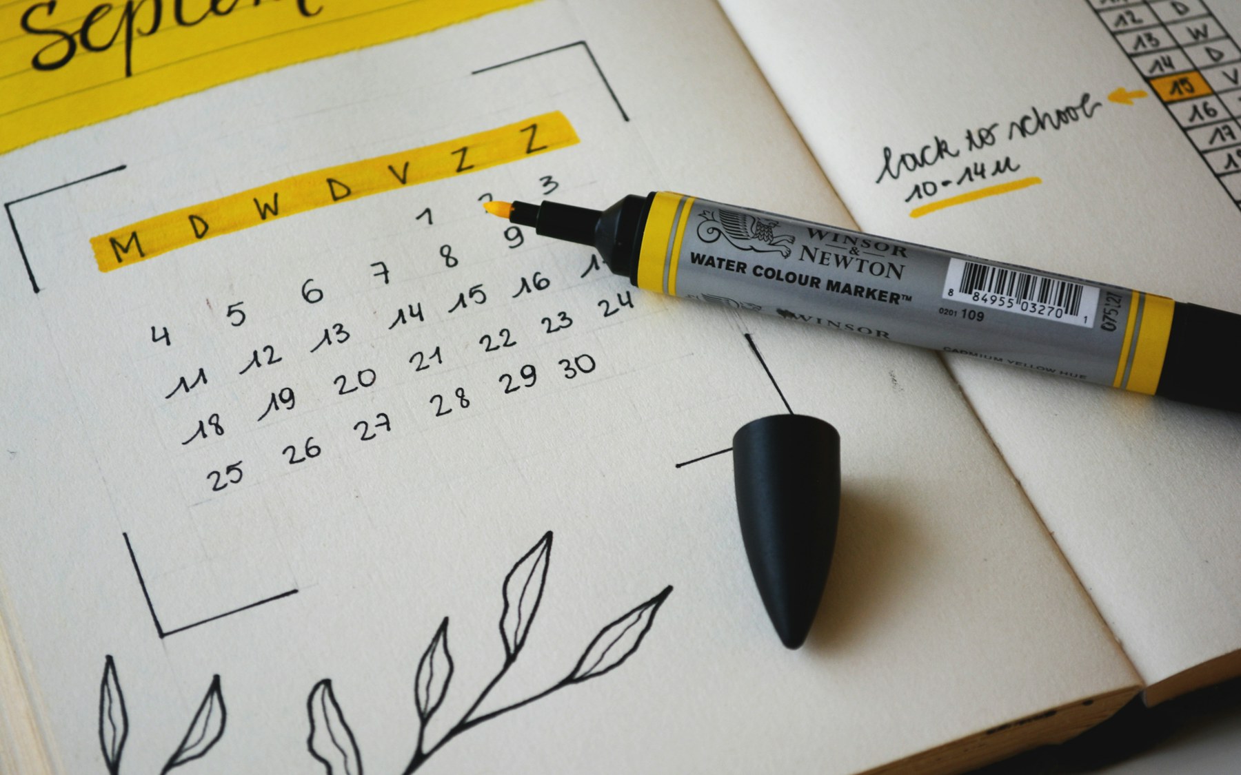 September calendar page in a planner beside a marker